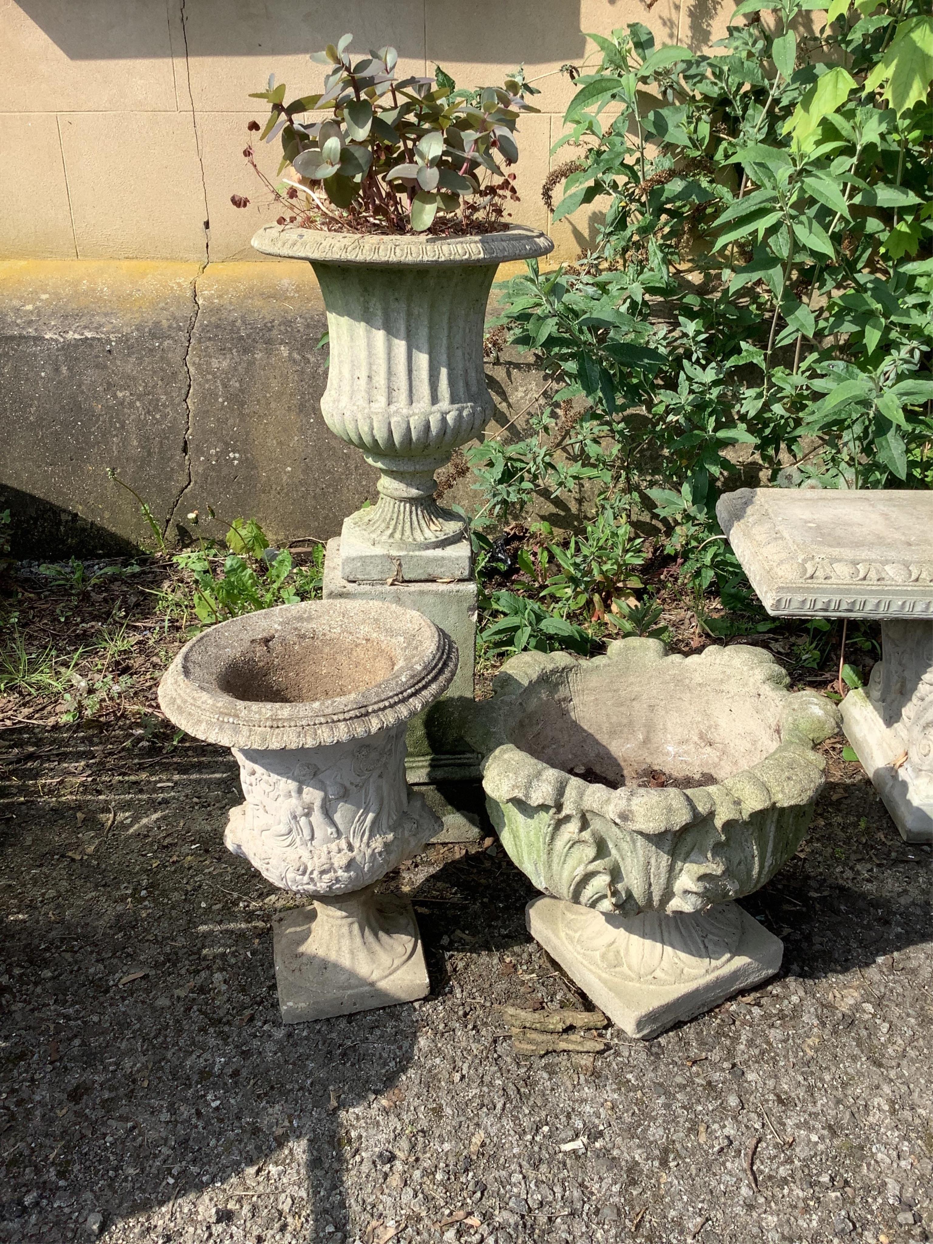 A reconstituted stone campana garden urn on square plinth, height 92cm together with two smaller stone garden urns